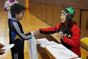 練習後に子どもたちにサインを手渡し、成長を願って握手をする大儀見選手