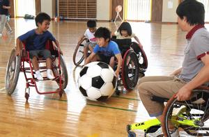 誰もが車いすに乗って行う「車いすサッカー」を楽しむ子どもたち。ボールを両手でパス！