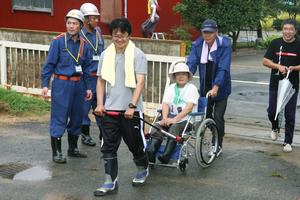 開発した道具を使って車椅子の避難者を運ぶ住民たち