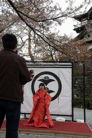 丸岡城の前で着物を羽織って写真を撮る親子