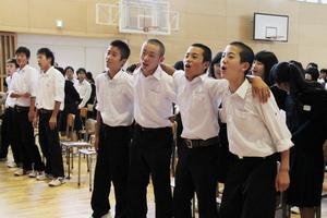 肩を組んで体を左右に揺らしながら校歌を歌い、一体感を味わう生徒たち