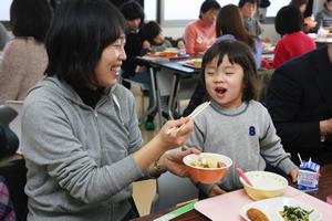 笑顔で話しながら給食を食べる親子