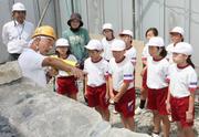 実施に使われている石を見ながら説明を受ける児童たち