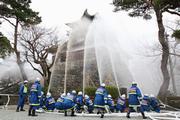 屋外消火栓や平章小学校のプールから水を吸い上げ、丸岡城に向かって一斉放水する消防団員