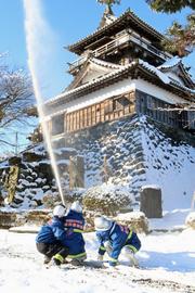 放水をして丸岡城への延焼防止訓練を図る消防団員