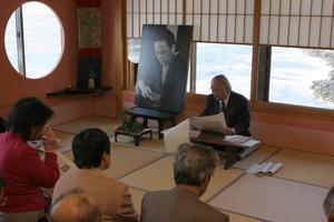 高見順の写真を掲げ、魅力を語る坂本氏