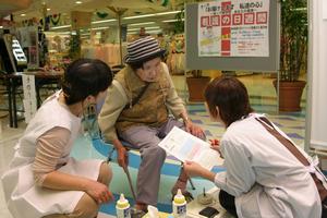 骨密度の計測結果をみて、看護師からアドバイスを受ける市民