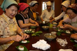 竹田地区の祭りではおなじみの「柿の葉ずし」作りを体験する参加者たち