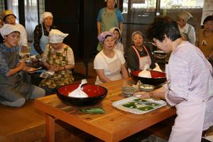 竹田地区の祭りではおなじみの「柿の葉ずし」作りを体験する参加者たち