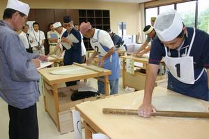 厳しい目が光る中、鍛え上げた腕を披露する参加者たち