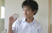 自分の名前が記された、生徒手帳サイズの委嘱状を手にする畑さん