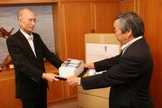 岡本代表取締役からリクールを寄贈される市長