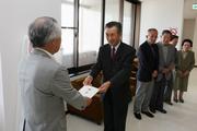 教育長に目録を手渡す豊原春雄丸岡支部長