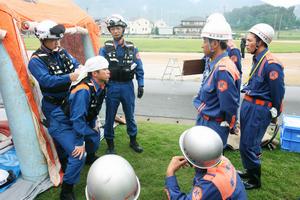 消防士から頭部などを怪我したときの応急手当法を学ぶ地区の消防団員たち