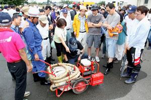 消防団員が地区に備え付けの軽可搬ポンプの使い方を指導