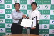 握手を交わす坂本市長と玄覺理事長