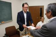 市長から委嘱状を手渡される江川誠一委員長