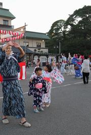 城を仰ぎながら、やぐらを囲んで踊る参加者たち