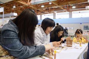 間伐材を使った立体パズルで、写真立てやペン立てを作る来場者たち