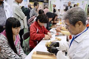 銅版を木槌でたたいたり、ペンチで折り曲げたりして折り鶴を作る体験コーナー