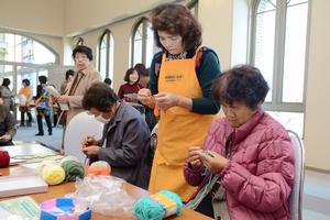 洗剤を使わなくても汚れをきれいに落とすアクリル毛糸たわしを編む参加者たち