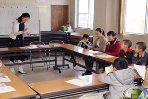 初参加の子どもたちに、落語の種類や組み立て方などを解説する木川さん(左)