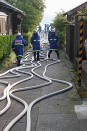九頭竜川から水を供給するため、細い路地いっぱいに伸びるホース