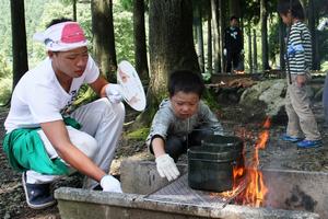 熱さに負けず、火を調整してご飯を炊く
