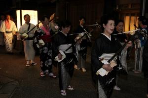 夜の街に響き渡る三味線と笛の音色