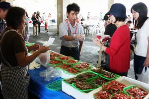 試食で味に納得。満足そうに魚を買い求める。