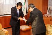 坂本市長に寄付金を手渡す山本代表取締役専務(左)