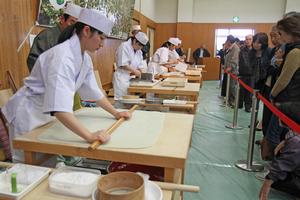 丸岡高校の生徒によるそば打ちの実演に多くの人が興味を持って見学