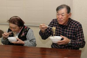 今年度は一反当り1俵ほど収穫でき、味もばっちりだと話す篤田親子