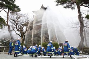 屋外消火栓や平章小学校のプールから水を吸い上げ、丸岡城に向かって一斉放水する消防団員