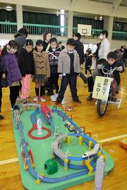 自転車をこいで電気を起こし、勢いよく新幹線を走らせる子どもたち