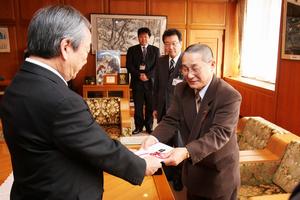 「地域の食育に役立ててほしい」と目録を手渡す