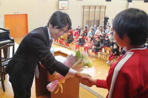 花束を受け取り、握手を交わす川村さん