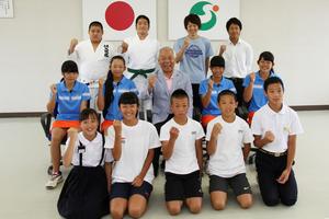 全国大会での活躍に向け拳を握る小学生から高等専門学校生までの選手一同と川元教育長