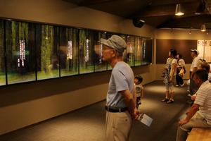 流れる文字から浮かび上がる手紙を見つめる来場者。現在の作品数は4,400点にのぼる