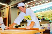 力強くそば生地を延ばす白崎龍神さん(丸岡高3年)。初段には高校生4人をはじめ、10人が挑んだ