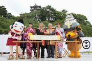 発起市の青森県弘前市・葛西憲之市長（中央右）が持参した同盟の巻物に署名し、固く握手を交わす市長ら