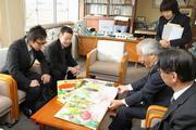 大きくてきれいな絵と愉快な内容に笑顔を見せる寺井支部長や同組合執行役員の脇尾圭一郎さん