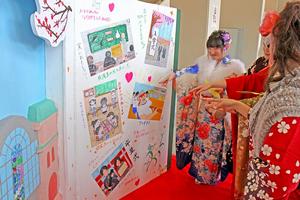 実行委員会が作成した記念パネルの前で歩み止め