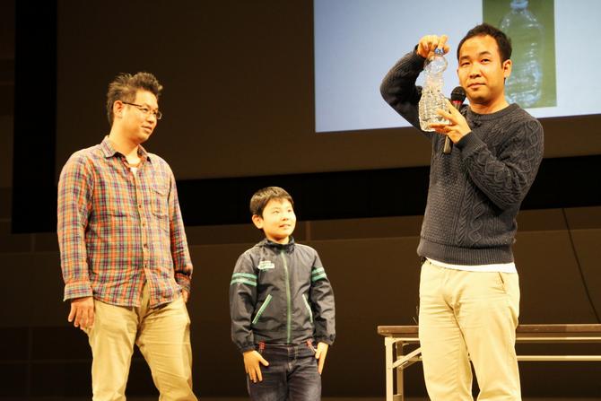 温暖化を起こす二酸化炭素を水に溶かす実験。溶けなくなると温暖化が加速すると話す天達氏(右)