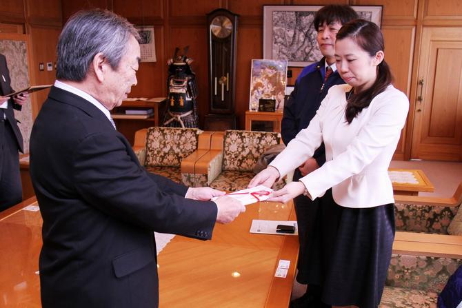 坂本市長へ目録を贈呈する地区委員の松浦亜希子(まつうら　あきこ)さん