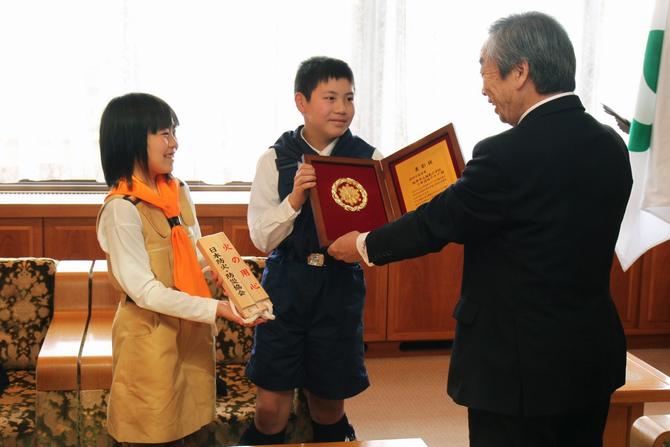 クラブ長の島野さん(中央)と道林南美さん(雄島小5年・左)が表彰盾と記念の拍子木を手に受賞を報告